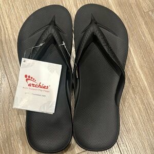 Archie’s black flip flops